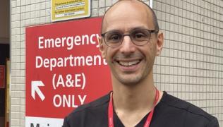 Dr Andrew Retter outside the emergency department sign at St Thomas' hospital. 