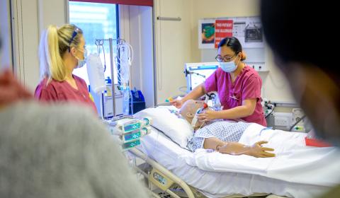 2 nurses training staff using a simulation manikin