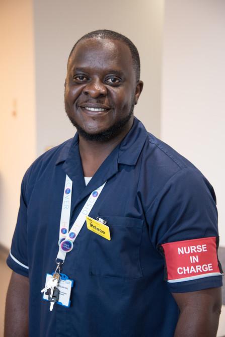 Male nurse in charge smiling in navy blue uniform in Cancer Centre