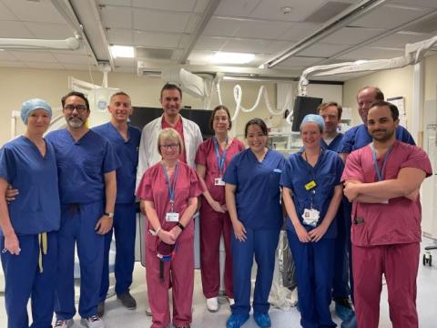 Surgical team which performed the UK first. Team are standing in a theatre, wearing coloured scrubs.