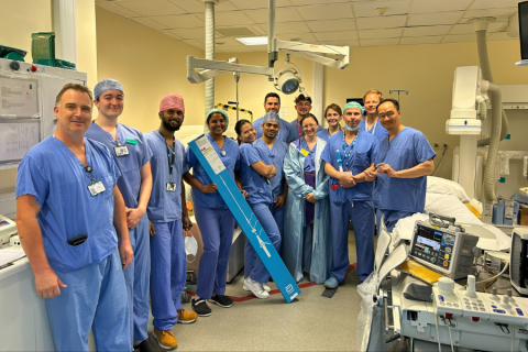 Image of hospital team involved in new pacemaker technology. They are all wearing blue scrubs with some of them wearing surgical hats.