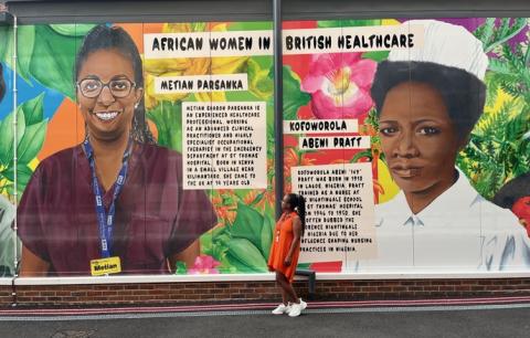 Metian Parsanka, an advanced clinical practitioner and highly specialist occupational therapist in the emergency department (A&E) at St Thomas’ Hospital, looking at the mural she features in at Guy's Hospital. The mural, celebrating African women in British healthcare, features 6 women including Metian Parsanka and Kofoworola Abeni ‘Ivy’ Pratt, who are pictured.